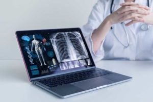 Photo d'un médecin devant son ordinateur montrant de l'imagerie médicale
